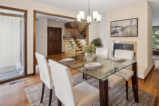 dining area with stairs, wood finished floors, and a chandelier