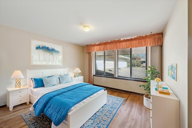 bedroom with light wood-style flooring and baseboards