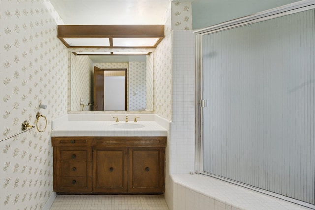 full bathroom featuring a stall shower, vanity, and wallpapered walls