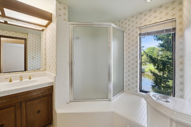 full bath with wallpapered walls, a shower stall, and vanity