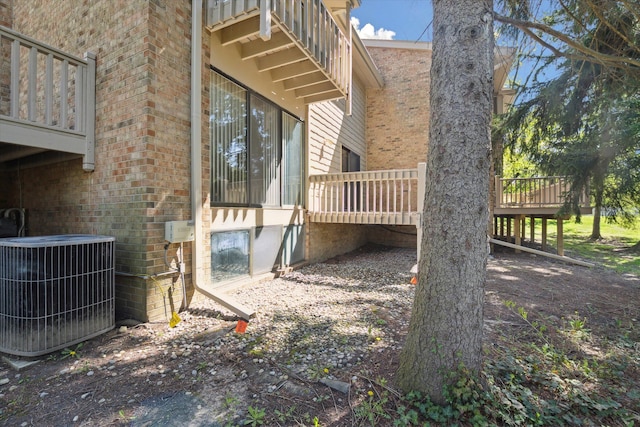 view of home's exterior with cooling unit and brick siding