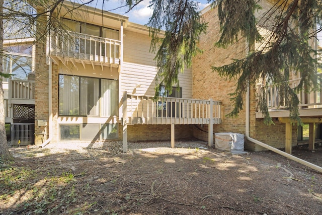 back of house with central air condition unit, a balcony, and a deck