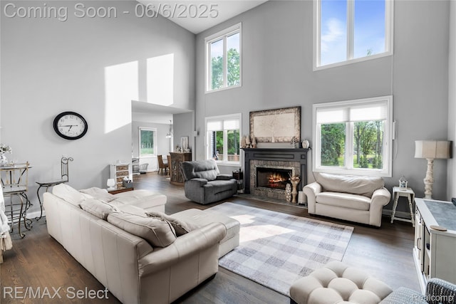 8320 Misty Mdws, Grand Blanc, MI 48439 - living area featuring a towering ceiling, a stone fireplace, and dark wood-style floors