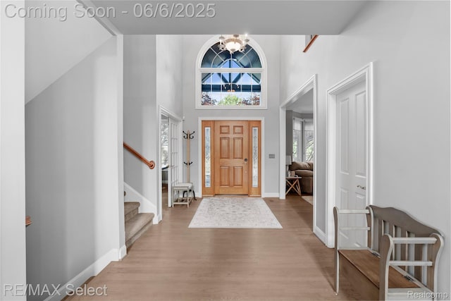 8320 Misty Mdws, Grand Blanc, MI 48439 - foyer with wood finished floors, a high ceiling, baseboards, stairway, and a chandelier