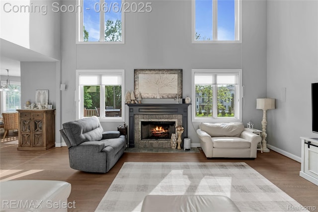 8320 Misty Mdws, Grand Blanc, MI 48439 - living area featuring a towering ceiling, a fireplace with flush hearth, wood finished floors, and healthy amount of natural light