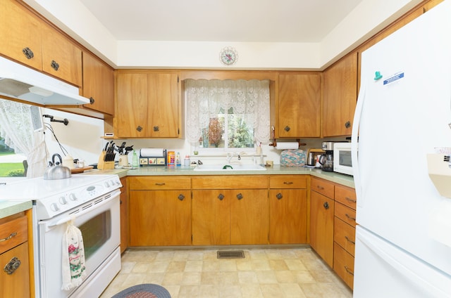 3683 Elmwood, Vassar, MI 48768 - kitchen with white appliances, a sink, light countertops, and brown cabinetry