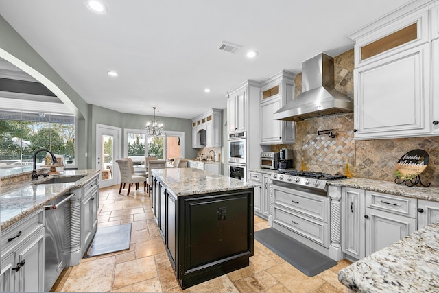 25031 Newton St, Dearborn, MI 48124 - kitchen with wall chimney exhaust hood, a sink, appliances with stainless steel finishes, stone tile floors, and decorative backsplash
