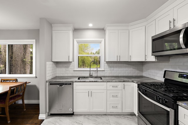 1090 S Williams Lake Rd, White Lake, MI 48386 - kitchen featuring stainless steel appliances, a sink, white cabinets, backsplash, and recessed lighting