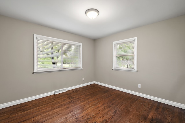 1090 S Williams Lake Rd, White Lake, MI 48386 - spare room featuring plenty of natural light, dark wood finished floors, and baseboards