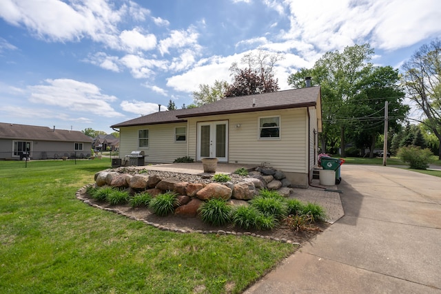 3142 Buss Dr, Commerce Twp, MI 48390 - rear view of property featuring french doors, a lawn, and a patio area