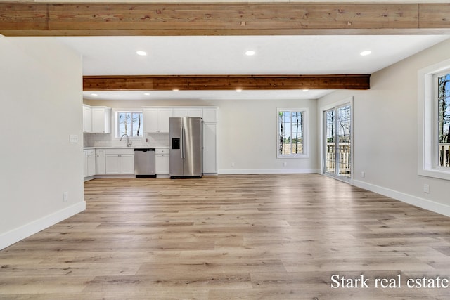 3339 N Weber Rd, Muskegon, MI 49445 - unfurnished living room featuring beam ceiling, plenty of natural light, light wood-style floors, and recessed lighting