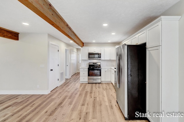 3339 N Weber Rd, Muskegon, MI 49445 - kitchen featuring stainless steel appliances, light wood-style floors, recessed lighting, white cabinetry, and beam ceiling