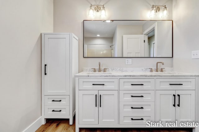 3339 N Weber Rd, Muskegon, MI 49445 - bathroom featuring wood finished floors, double vanity, a shower, and baseboards