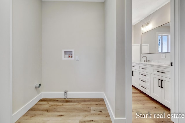 3339 N Weber Rd, Muskegon, MI 49445 - laundry area with washer hookup, light wood finished floors, and baseboards