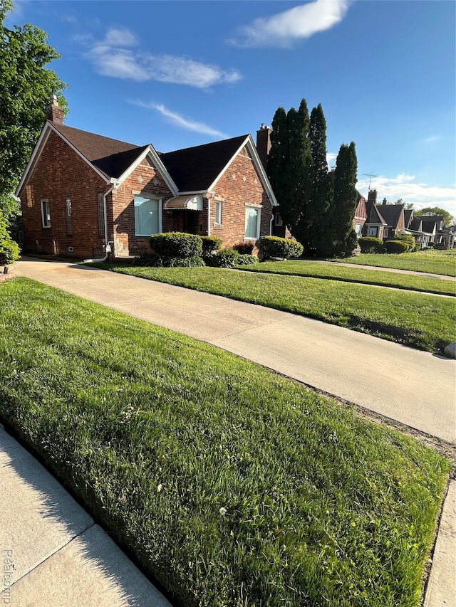 11520 Engleside St, Detroit, MI 48205 - view of front facade with a chimney, brick siding, a front yard, and driveway
