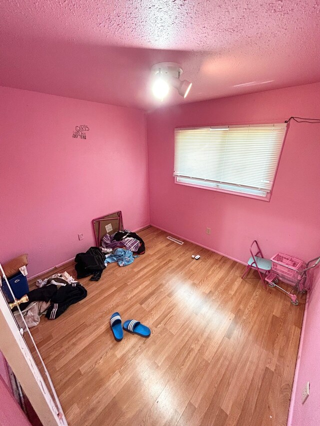 1622 Barbara Dr, Flint, MI 48504 - unfurnished bedroom featuring wood finished floors and a textured ceiling