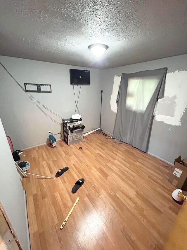 1622 Barbara Dr, Flint, MI 48504 - workout area featuring a textured ceiling, wood finished floors, and baseboards