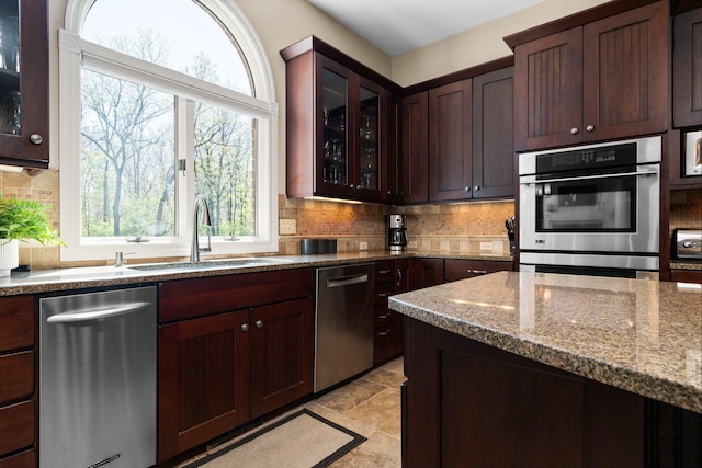 1303 Towsley Ln, Ann Arbor, MI 48105 - kitchen with appliances with stainless steel finishes, a sink, stone counters, and tasteful backsplash