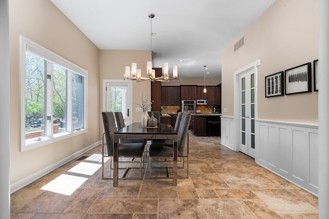 1303 Towsley Ln, Ann Arbor, MI 48105 - dining room featuring stone finish floors, a chandelier, and baseboards