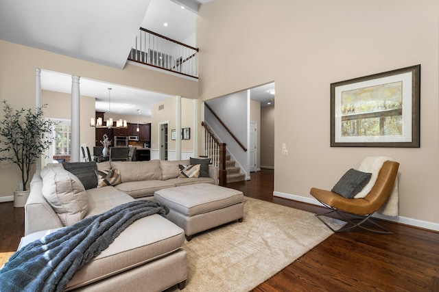 1303 Towsley Ln, Ann Arbor, MI 48105 - living area featuring wood finished floors, stairs, baseboards, a high ceiling, and ornate columns