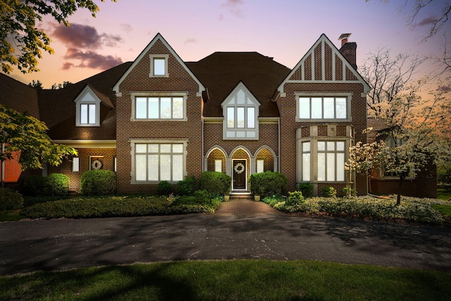 1303 Towsley Ln, Ann Arbor, MI 48105 - tudor-style house featuring a chimney and brick siding