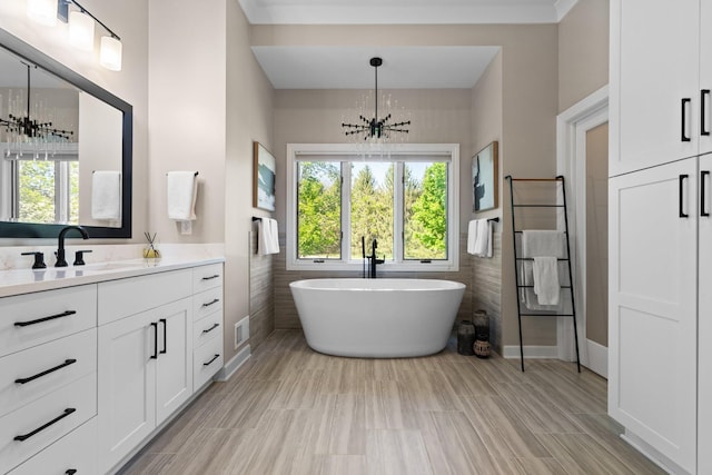 1303 Towsley Ln, Ann Arbor, MI 48105 - bathroom with a soaking tub, vanity, tile walls, a chandelier, and a wainscoted wall