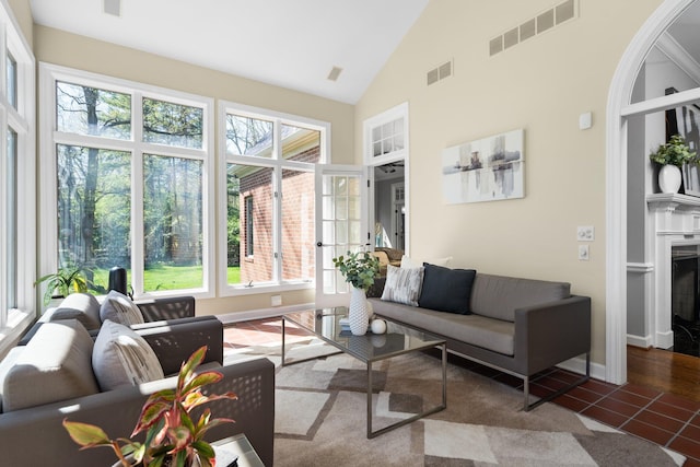 1303 Towsley Ln, Ann Arbor, MI 48105 - living area with plenty of natural light, high vaulted ceiling, a fireplace, tile patterned floors, and baseboards