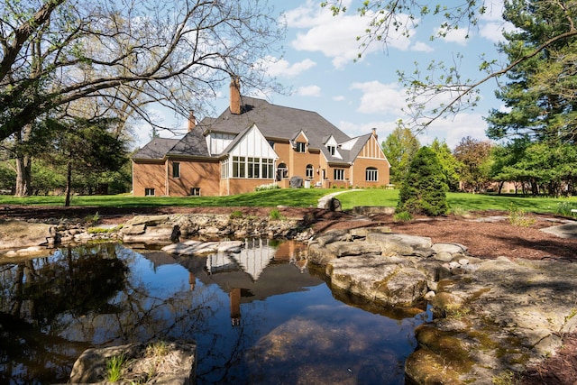 1303 Towsley Ln, Ann Arbor, MI 48105 - back of house with a chimney and a lawn