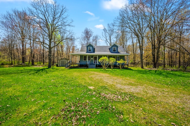 view of front of home with covered porch, a shed, an outbuilding, and a front yard