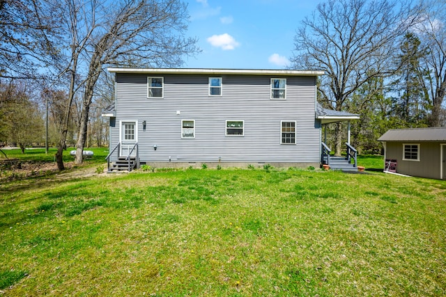 back of house with a lawn and entry steps