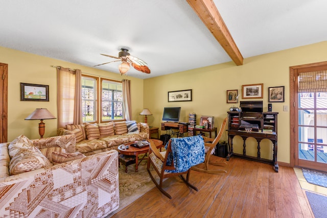 living room with wood-type flooring, a ceiling fan, beam ceiling, and baseboards
