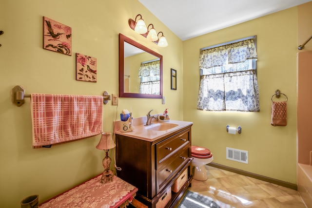 bathroom featuring toilet, vanity, a bathtub, and baseboards