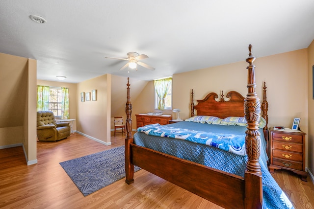 bedroom with multiple windows, wood finished floors, and baseboards