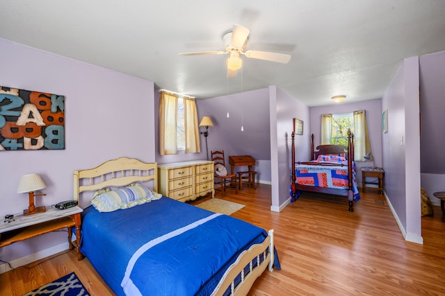 bedroom with baseboards, light wood-style floors, and a ceiling fan