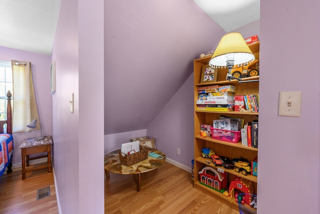 game room featuring wood finished floors and vaulted ceiling