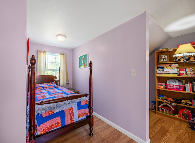 bedroom with wood finished floors and baseboards