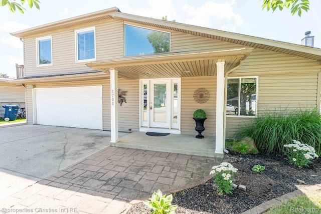 1700 Maddy Ln, Keego Harbor, MI 48320 - view of front facade featuring an attached garage, driveway, and covered porch