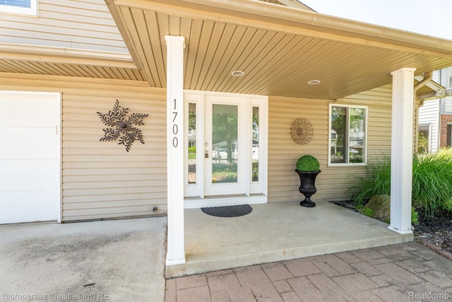 1700 Maddy Ln, Keego Harbor, MI 48320 - view of exterior entry with covered porch and a garage