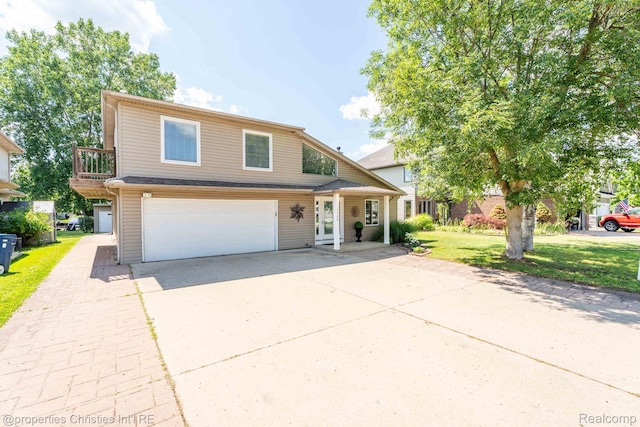 1700 Maddy Ln, Keego Harbor, MI 48320 - view of front of property with an attached garage, driveway, and a front lawn