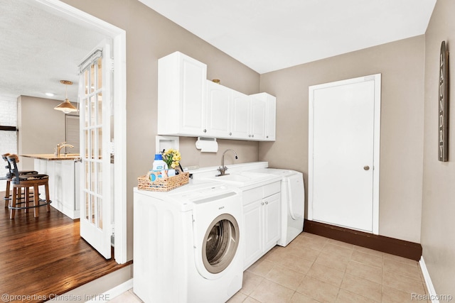 1700 Maddy Ln, Keego Harbor, MI 48320 - laundry area featuring washer / clothes dryer, cabinet space, and light tile patterned floors