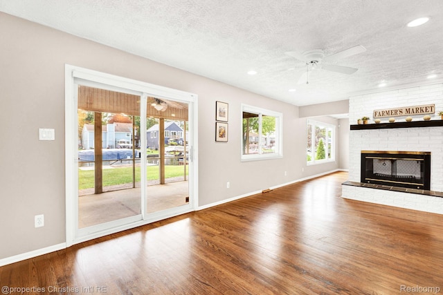 1700 Maddy Ln, Keego Harbor, MI 48320 - unfurnished living room featuring a ceiling fan, a fireplace, wood finished floors, a textured ceiling, and recessed lighting