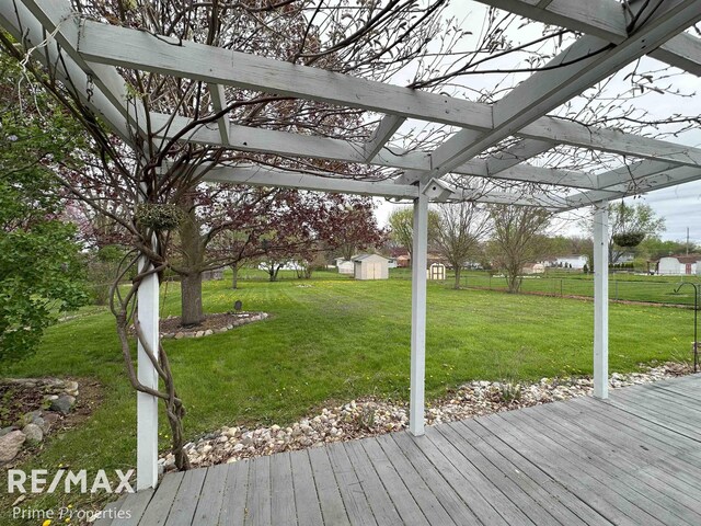 1321 Rollins St, Grand Blanc, MI 48439 - wooden deck featuring a shed, an outdoor structure, a pergola, and a lawn