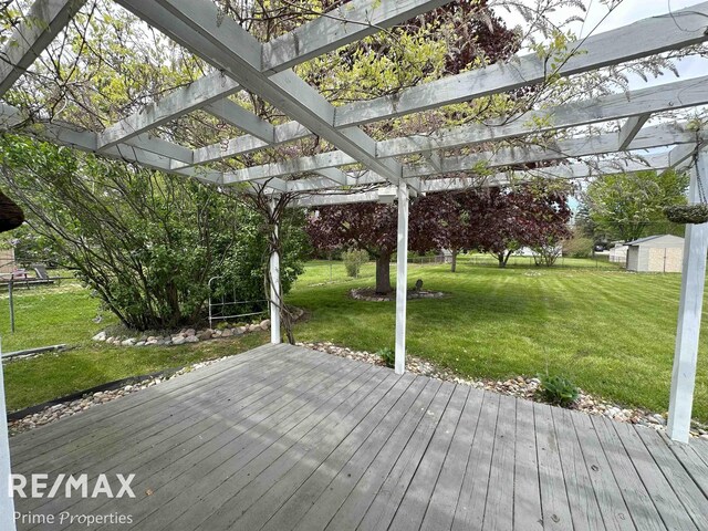 1321 Rollins St, Grand Blanc, MI 48439 - deck featuring a pergola, a yard, a storage unit, and an outdoor structure