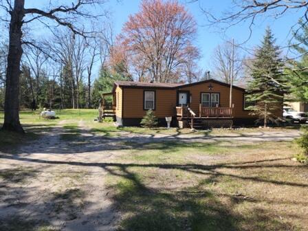 4297 N Wilderness Trl, Luther, MI 49656 - manufactured / mobile home with a wooden deck and a front yard