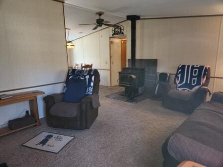 4297 N Wilderness Trl, Luther, MI 49656 - living area featuring a ceiling fan, a wood stove, and carpet flooring