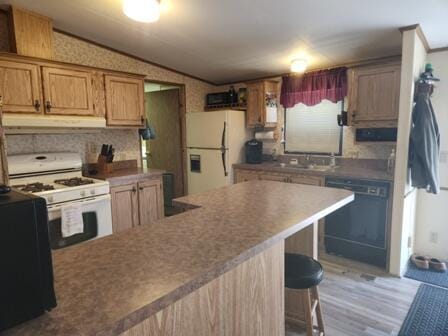 4297 N Wilderness Trl, Luther, MI 49656 - kitchen featuring white appliances, under cabinet range hood, a breakfast bar, wood finished floors, and lofted ceiling