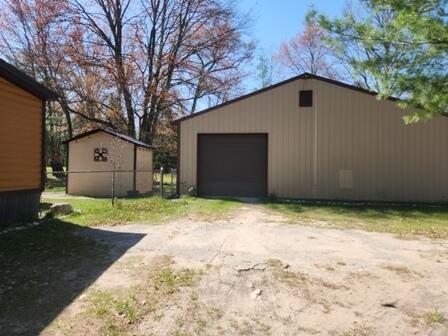 4297 N Wilderness Trl, Luther, MI 49656 - detached garage featuring driveway