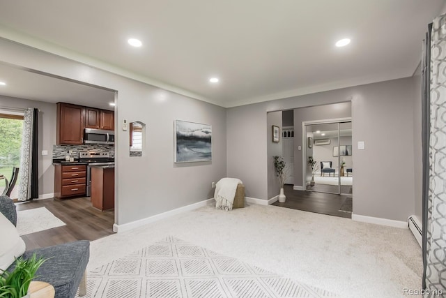 4290 Frostwood, Troy, MI 48098 - living room featuring baseboard heating, baseboards, recessed lighting, dark carpet, and a wall unit AC