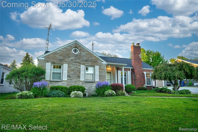 2302 Radcliffe Ave, Flint, MI 48503 - view of front of property with stone siding, a front lawn, and a chimney