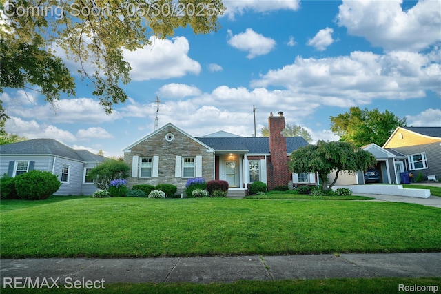 2302 Radcliffe Ave, Flint, MI 48503 - view of front facade with stone siding, a chimney, a front lawn, and concrete driveway